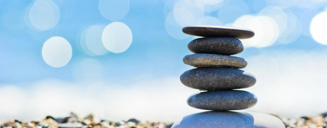 Flat rocks piled and balanced on water shoreline